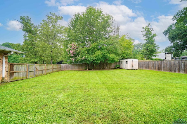 view of yard featuring a shed, an outdoor structure, and a fenced backyard