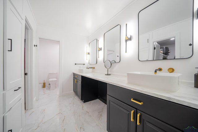 bathroom with double vanity, toilet, ornamental molding, marble finish floor, and a sink