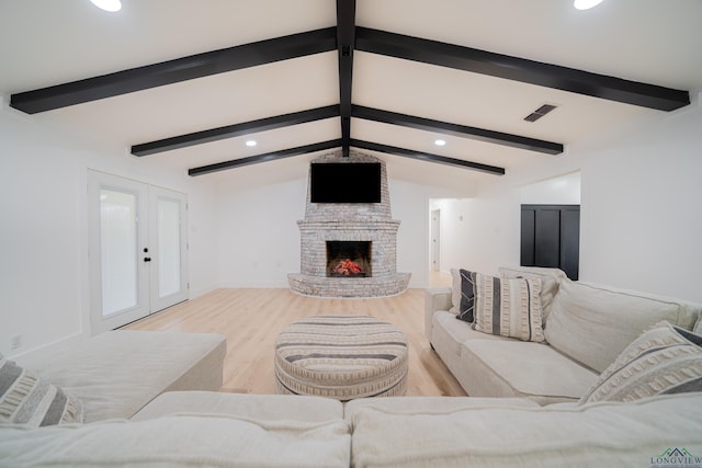 living area with french doors, a fireplace, vaulted ceiling with beams, visible vents, and light wood-type flooring