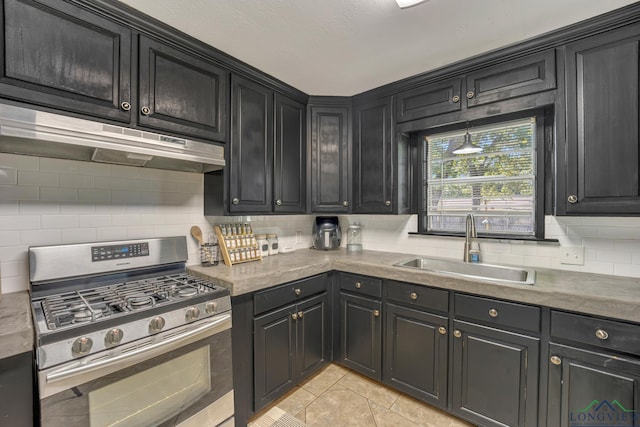 kitchen with light tile patterned floors, tasteful backsplash, stainless steel gas range oven, and sink