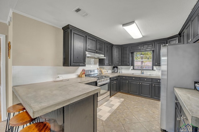 kitchen featuring sink, light tile patterned floors, appliances with stainless steel finishes, kitchen peninsula, and a breakfast bar area