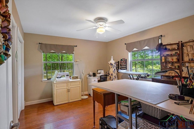office featuring healthy amount of natural light, light wood-type flooring, ceiling fan, and baseboards