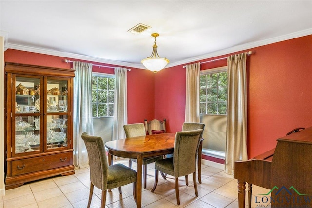 dining area featuring crown molding, light tile patterned flooring, and baseboards