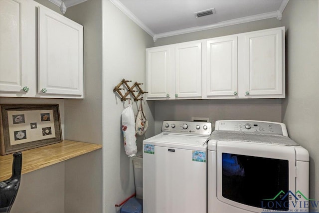 laundry room featuring washer and clothes dryer, cabinet space, and crown molding