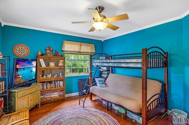 bedroom featuring wood finished floors, crown molding, baseboards, and ceiling fan