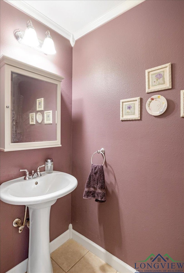 bathroom featuring tile patterned flooring, ornamental molding, and baseboards