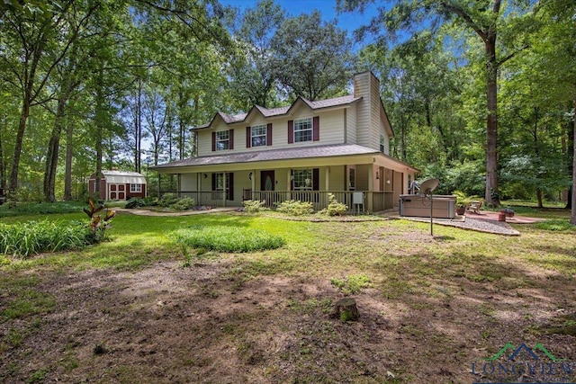 view of front of home with a hot tub, a storage unit, a chimney, an outbuilding, and a front lawn