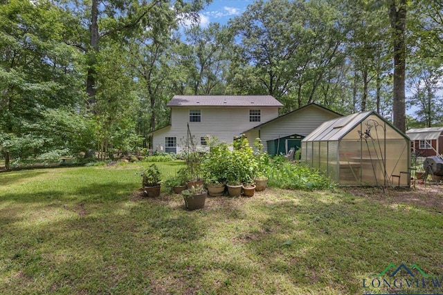 rear view of property with an exterior structure, an outbuilding, and a yard