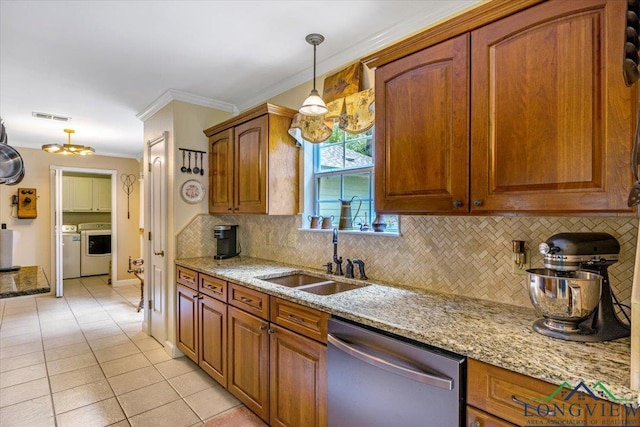 kitchen with stainless steel dishwasher, a sink, crown molding, washer and clothes dryer, and backsplash