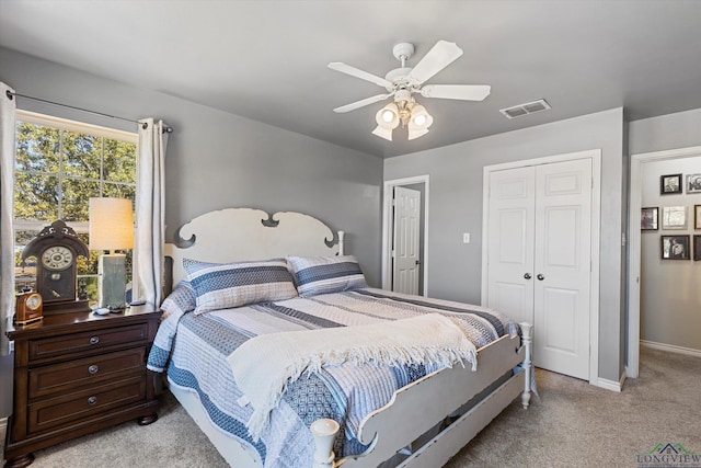 bedroom featuring a closet, light colored carpet, and ceiling fan