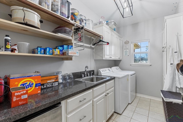 laundry area featuring separate washer and dryer, sink, light tile patterned flooring, and cabinets