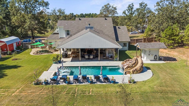 rear view of property with a lawn, a patio area, outdoor lounge area, and a storage unit