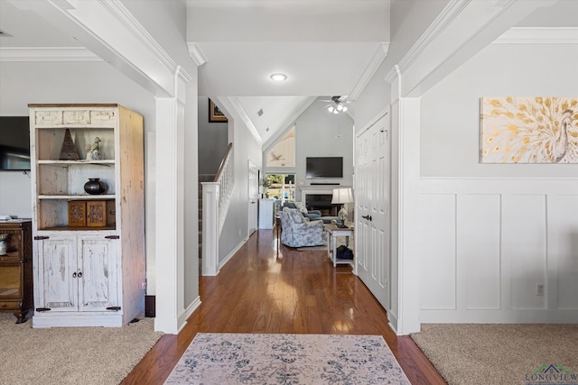 hall with vaulted ceiling, crown molding, and dark hardwood / wood-style floors