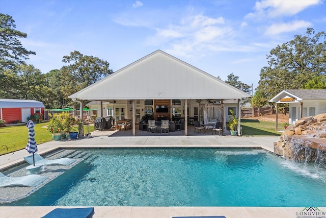 view of pool featuring a lawn, ceiling fan, a patio area, and pool water feature