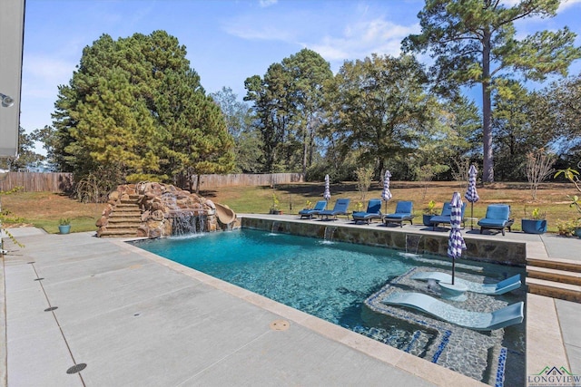 view of swimming pool featuring pool water feature, a patio area, and a lawn