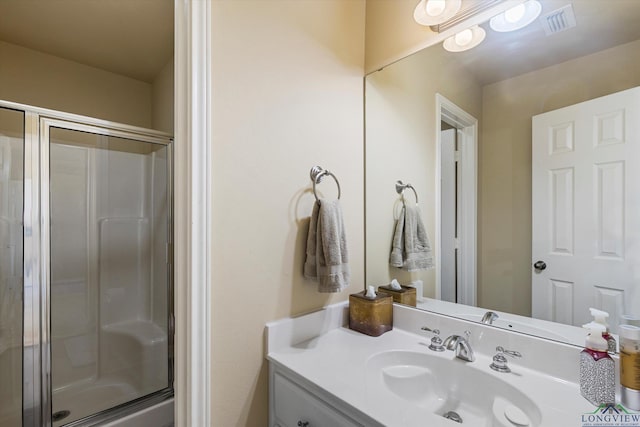 bathroom featuring vanity and a shower with shower door