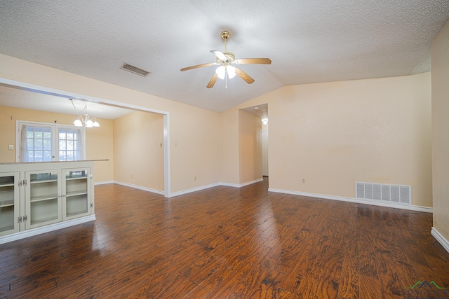 spare room with a textured ceiling, ceiling fan with notable chandelier, lofted ceiling, and dark wood-type flooring