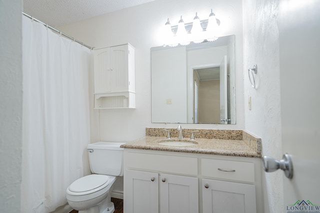 bathroom featuring vanity, a textured ceiling, and toilet