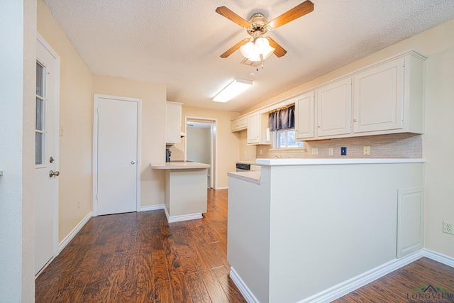 kitchen with kitchen peninsula, backsplash, ceiling fan, dark wood-type flooring, and white cabinets