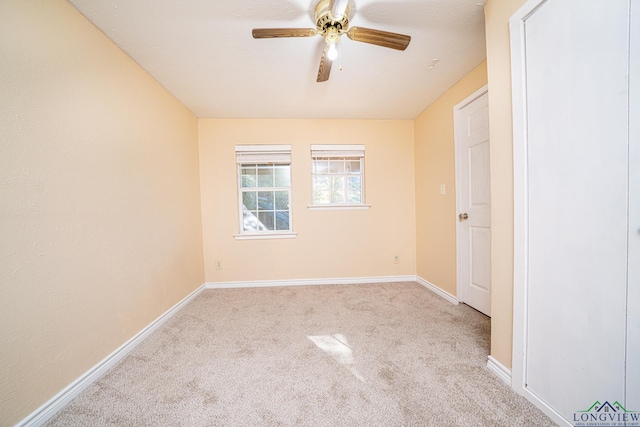 carpeted spare room featuring ceiling fan