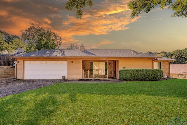 ranch-style home with a garage and a lawn