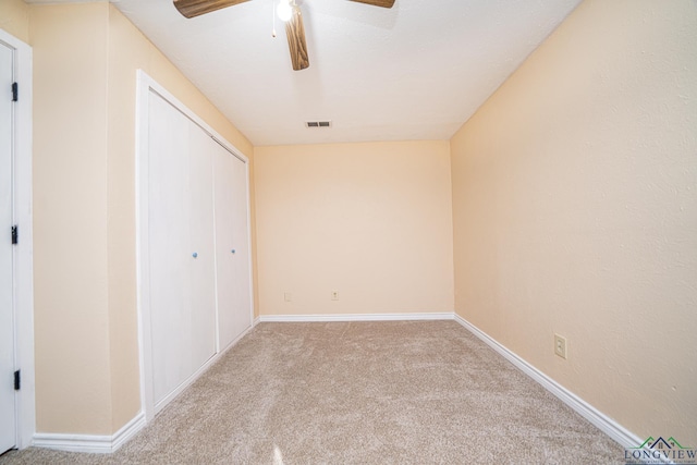 unfurnished bedroom with ceiling fan, a closet, and light colored carpet