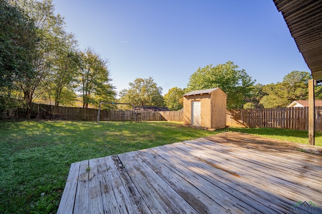 wooden terrace featuring a yard and a storage unit