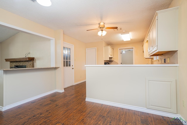 kitchen featuring white cabinets, ceiling fan, kitchen peninsula, and dark wood-type flooring