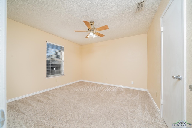 carpeted spare room featuring a textured ceiling and ceiling fan