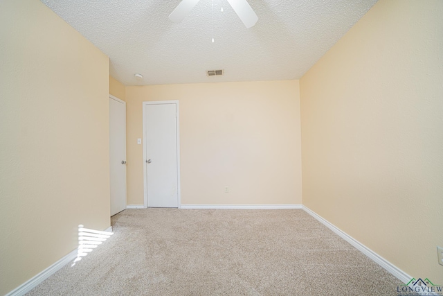 carpeted empty room featuring ceiling fan and a textured ceiling