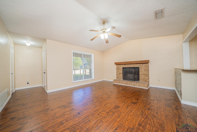 unfurnished living room with ceiling fan, a brick fireplace, dark hardwood / wood-style floors, a textured ceiling, and lofted ceiling