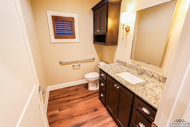 bathroom with hardwood / wood-style floors, vanity, and toilet