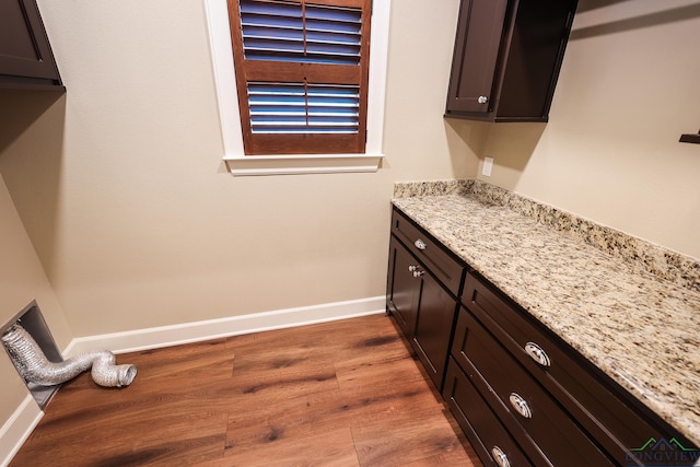 laundry area with dark hardwood / wood-style floors and cabinets