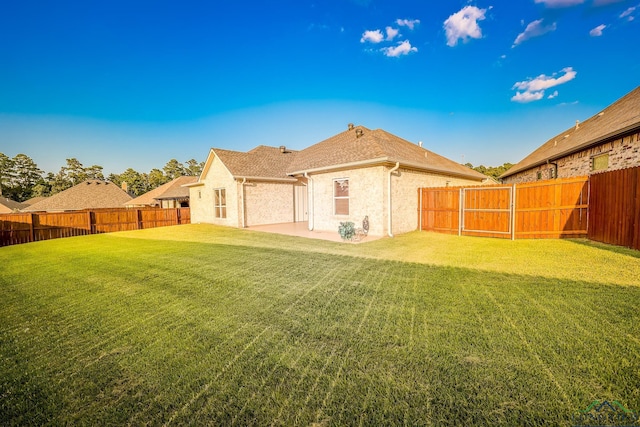 back of house featuring a patio area and a lawn