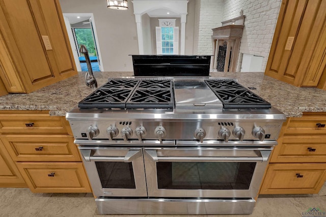 kitchen featuring light stone countertops and double oven range