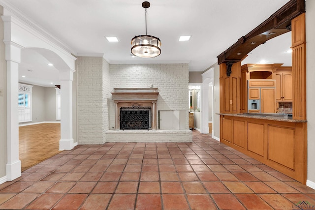 unfurnished living room featuring tile patterned floors, a fireplace, a chandelier, and ornamental molding