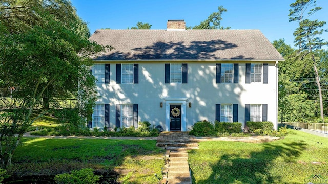 colonial home with a front lawn