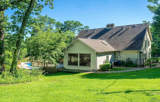 back of house featuring a yard, cooling unit, and a wooden deck