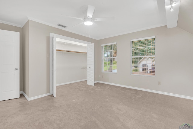 unfurnished bedroom featuring ceiling fan, a closet, light colored carpet, and vaulted ceiling