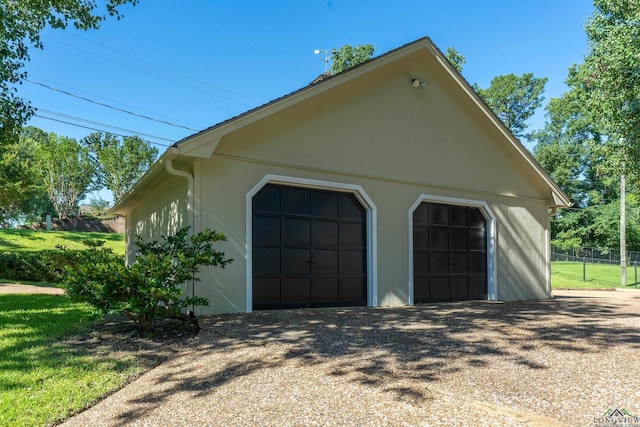 view of side of home with a garage and an outbuilding