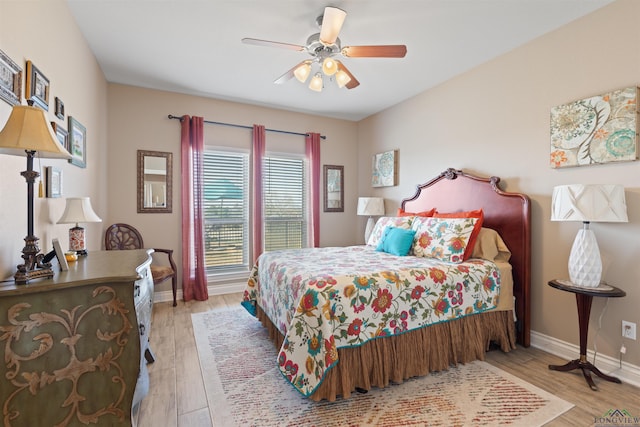 bedroom featuring a ceiling fan, baseboards, and wood finished floors