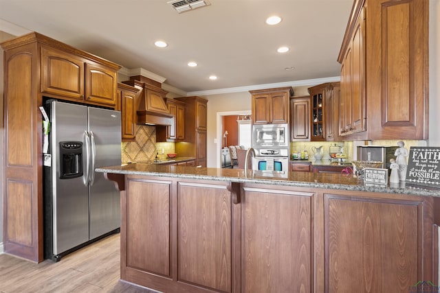 kitchen featuring visible vents, a peninsula, dark stone counters, glass insert cabinets, and appliances with stainless steel finishes