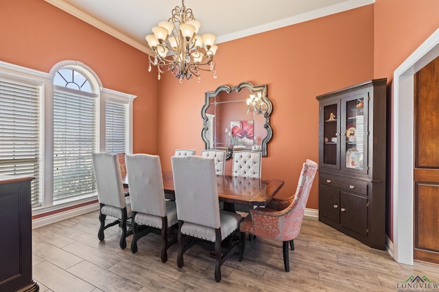 dining room featuring a notable chandelier, light wood-type flooring, baseboards, and ornamental molding