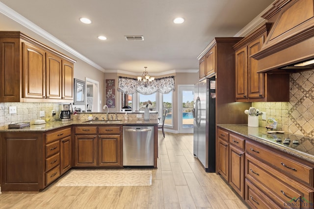 kitchen featuring visible vents, premium range hood, an inviting chandelier, a sink, and stainless steel appliances