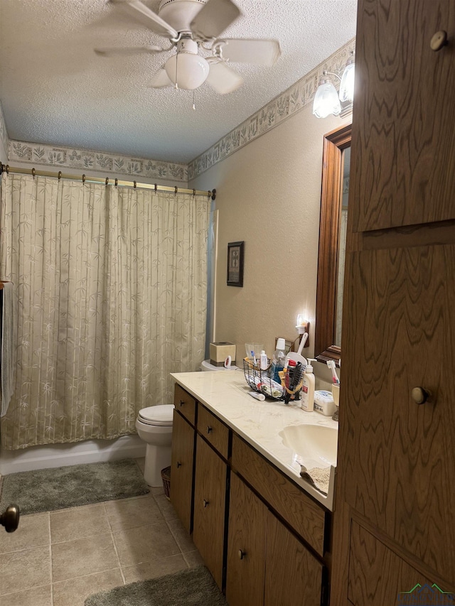 full bathroom featuring vanity, ceiling fan, toilet, shower / bathtub combination with curtain, and a textured ceiling