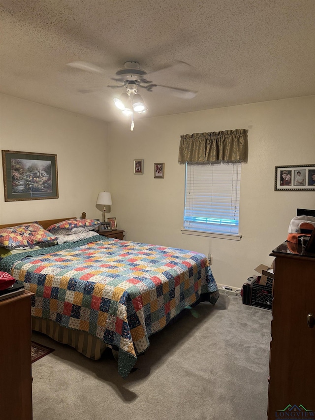 bedroom with ceiling fan, light colored carpet, and a textured ceiling