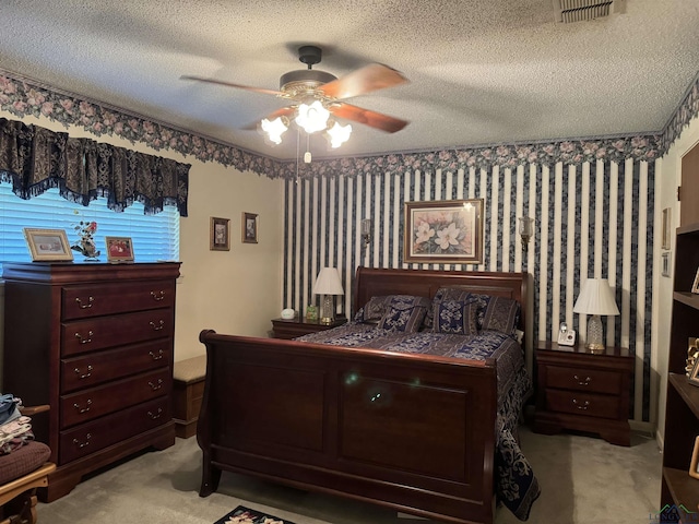 bedroom featuring ceiling fan, light carpet, and a textured ceiling