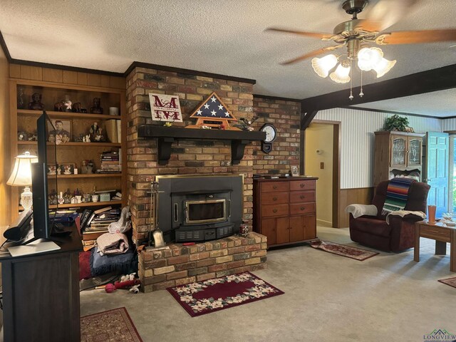 living room featuring ceiling fan, wood walls, a wood stove, and a textured ceiling