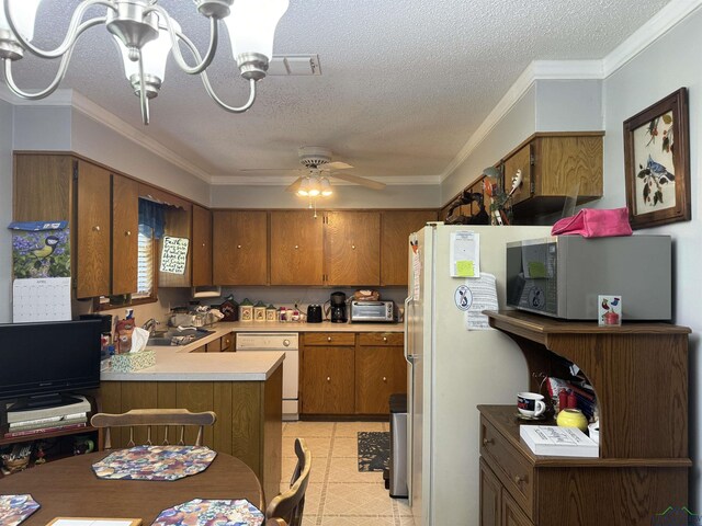 kitchen featuring a textured ceiling, white appliances, and kitchen peninsula