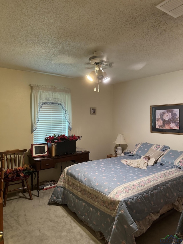 carpeted bedroom with ceiling fan and a textured ceiling